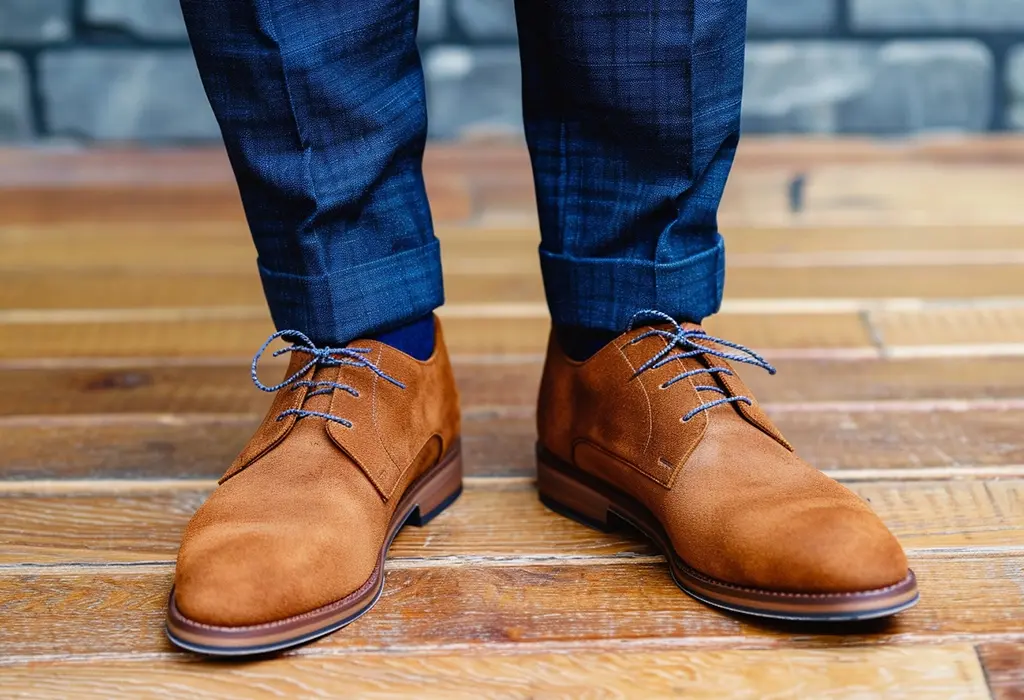 man wearing suede shoes with blue laces