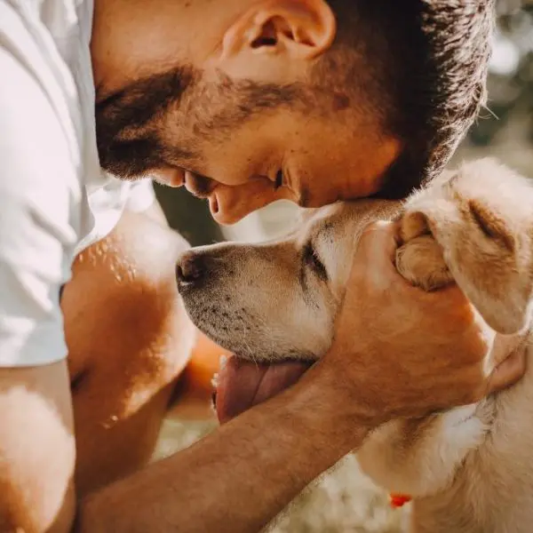 man holding dog with affection