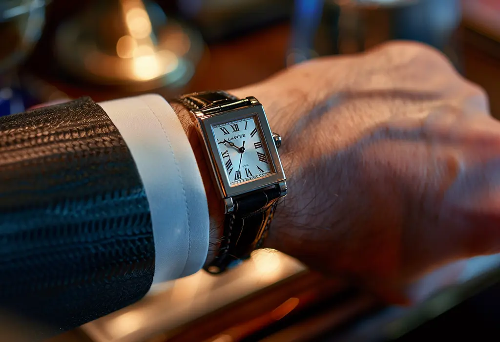 man’s wrist wearing a thin, rectangular watch