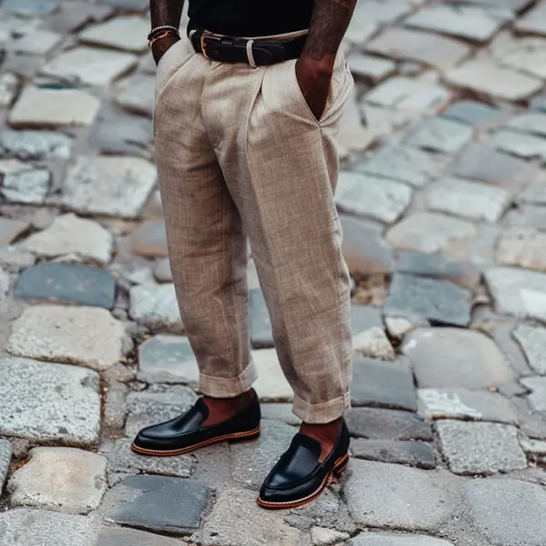 man wearing relaxed-fit beige linen pants with a black t-shirt, black leather belt, and black loafers