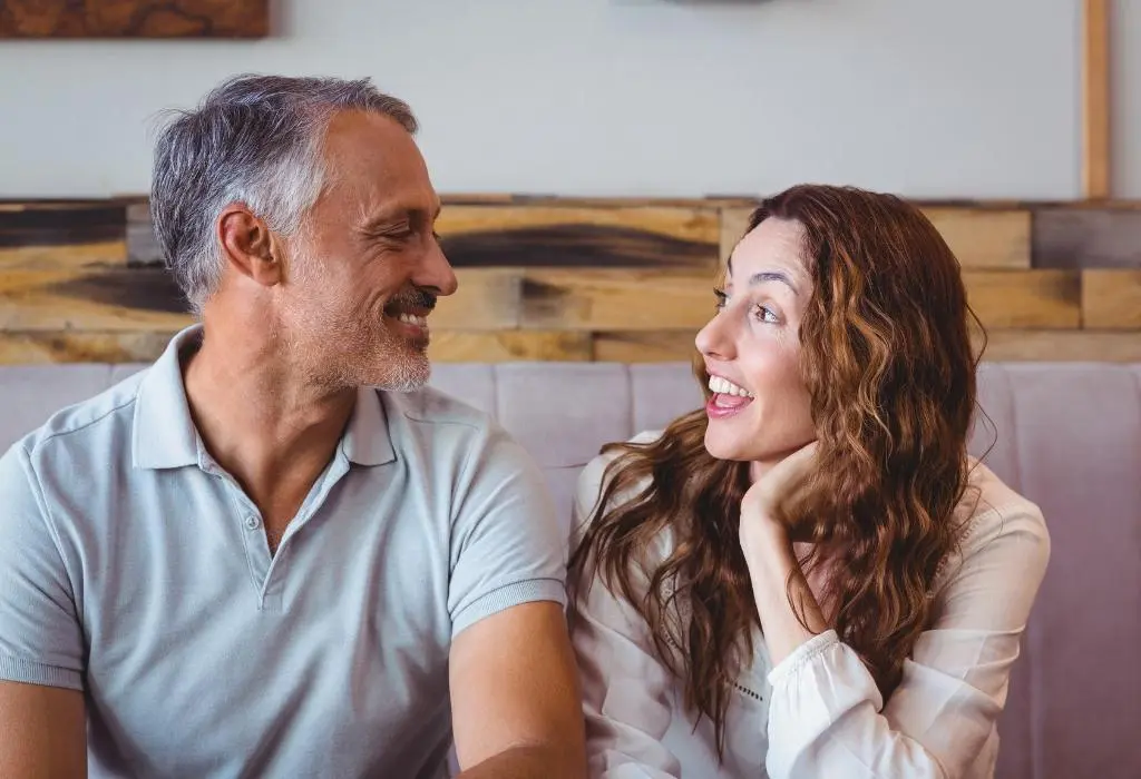 younger woman laughing at older man's joke